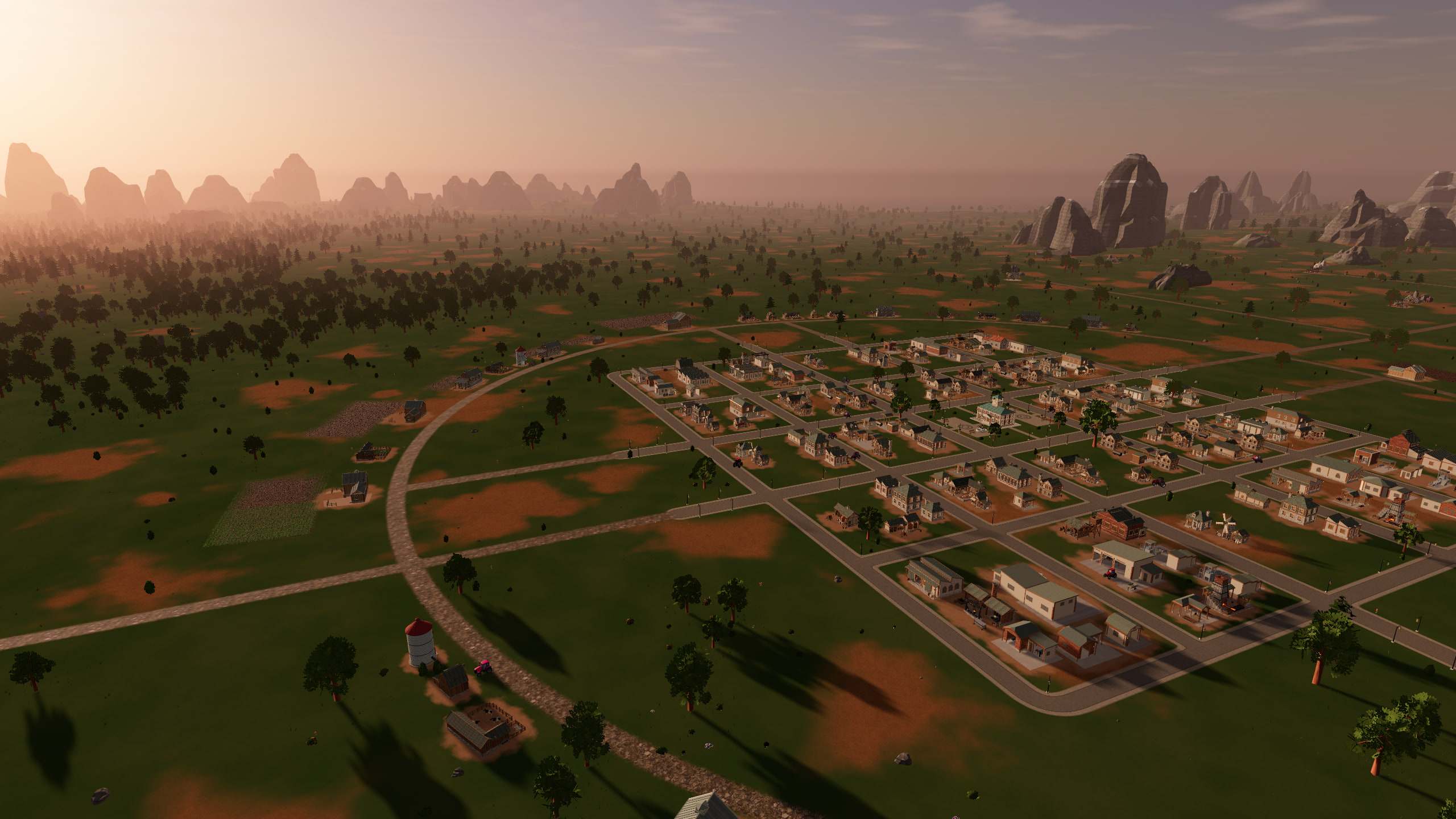 The town and its ring road from the air at golden hour, with fields all around.